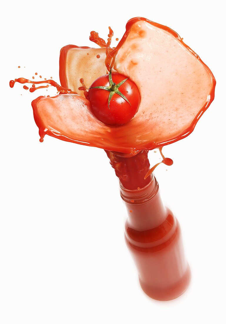 Tomato juice splashing out of bottle
