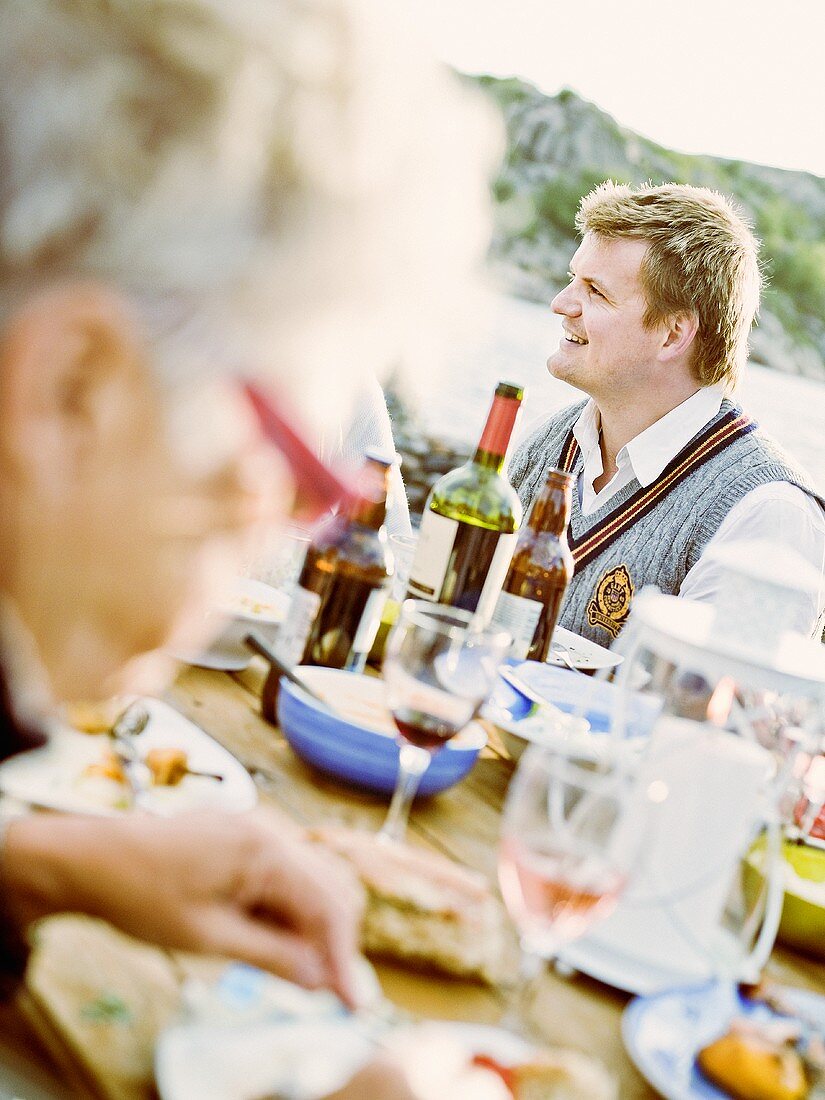 Seated man at an outdoor dinner party
