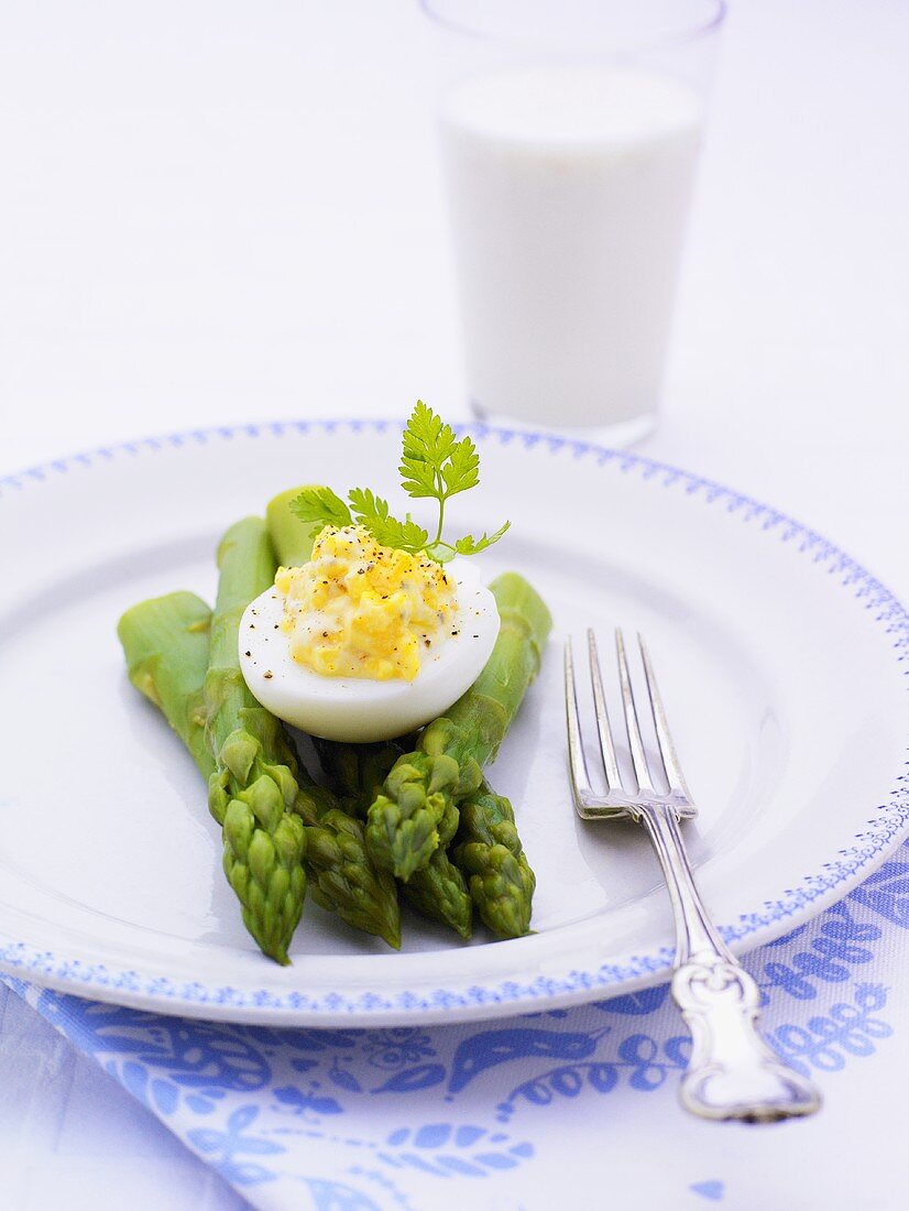 Green asparagus with egg, glass of milk