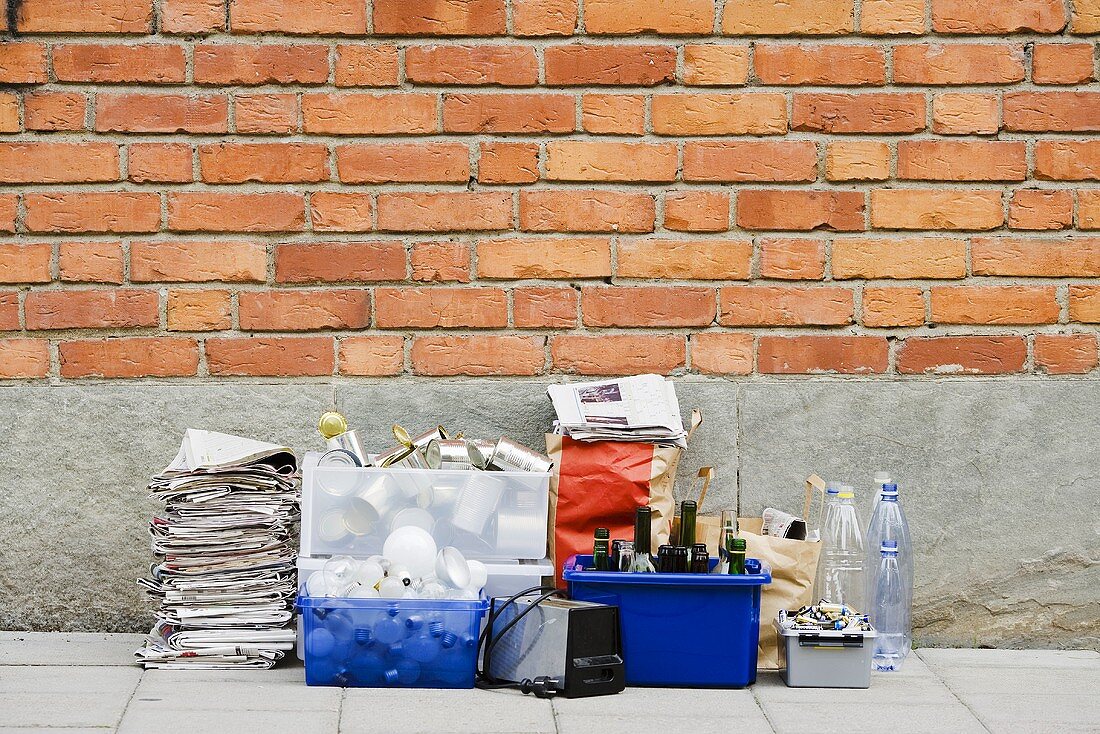 Waste sorted for recycling by brick wall