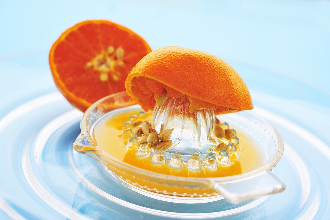 Squeezing a mandarin orange with a citrus squeezer