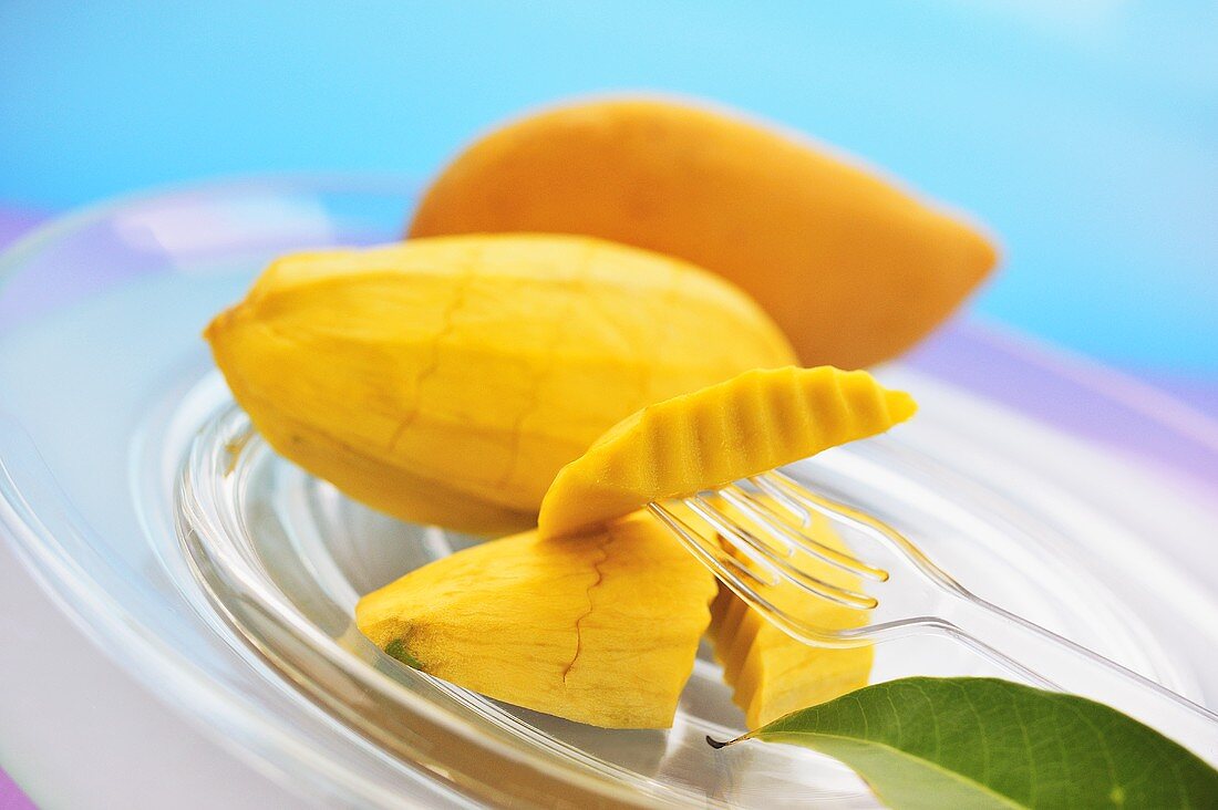 Yellow Thai mangos, peeled and unpeeled