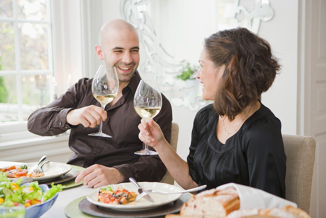 Mann und Frau stoßen mit einem Glas Wein an