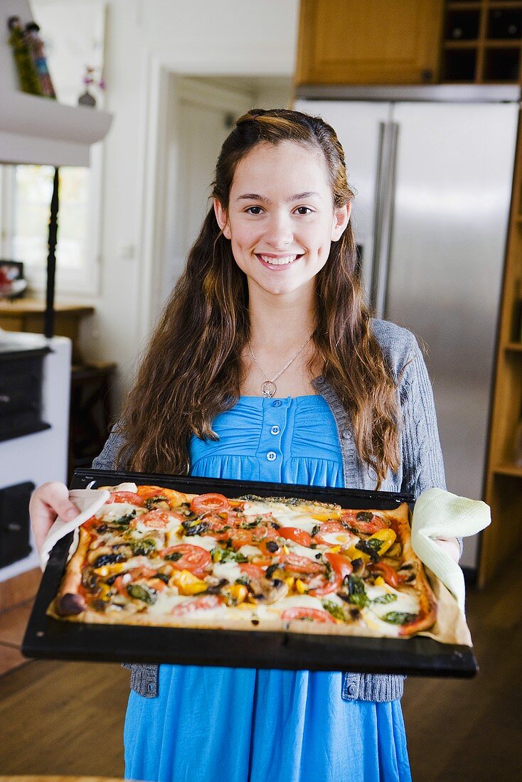 Young girl with a tray of pizza