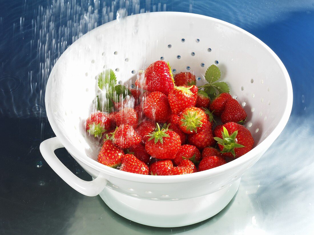 Washing strawberries in colander