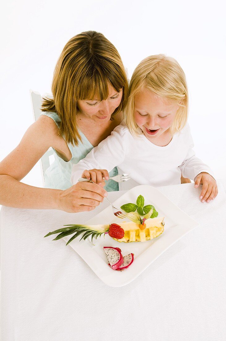 Mutter und Tochter essen Obst vom Obstteller