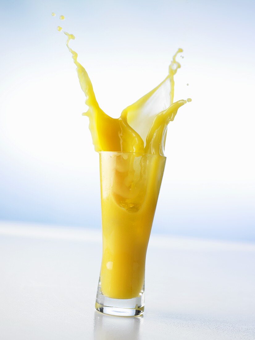 Orangensaft in ein Glas gießen (Splash)