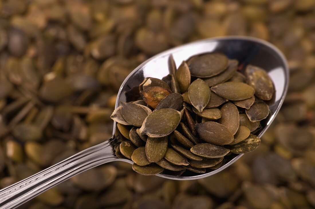 Pumpkin seeds on spoon (close-up)