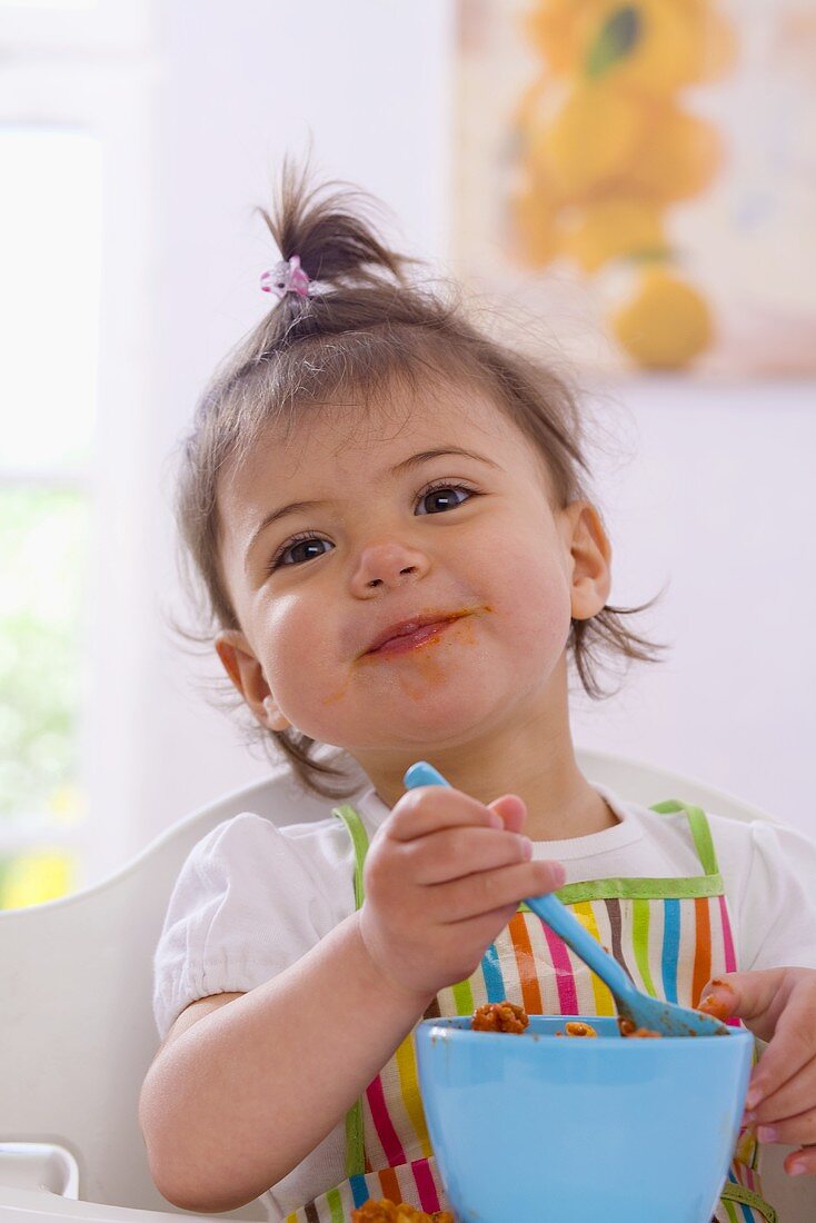 Mädchen isst Nudeln mit Sauce Bolognese