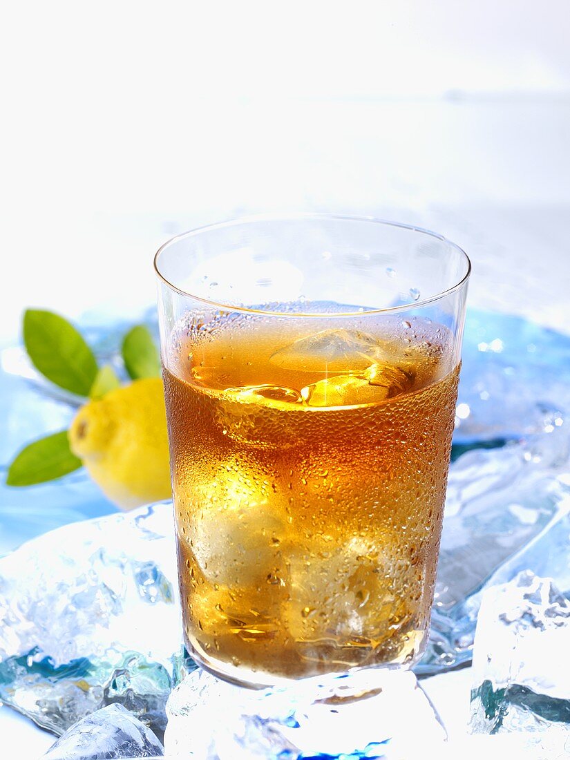 A glass of iced tea on ice with lemon