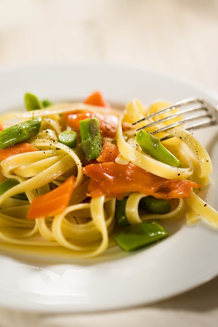 Salmon and Asparagus Pasta on a White Plate; Fork