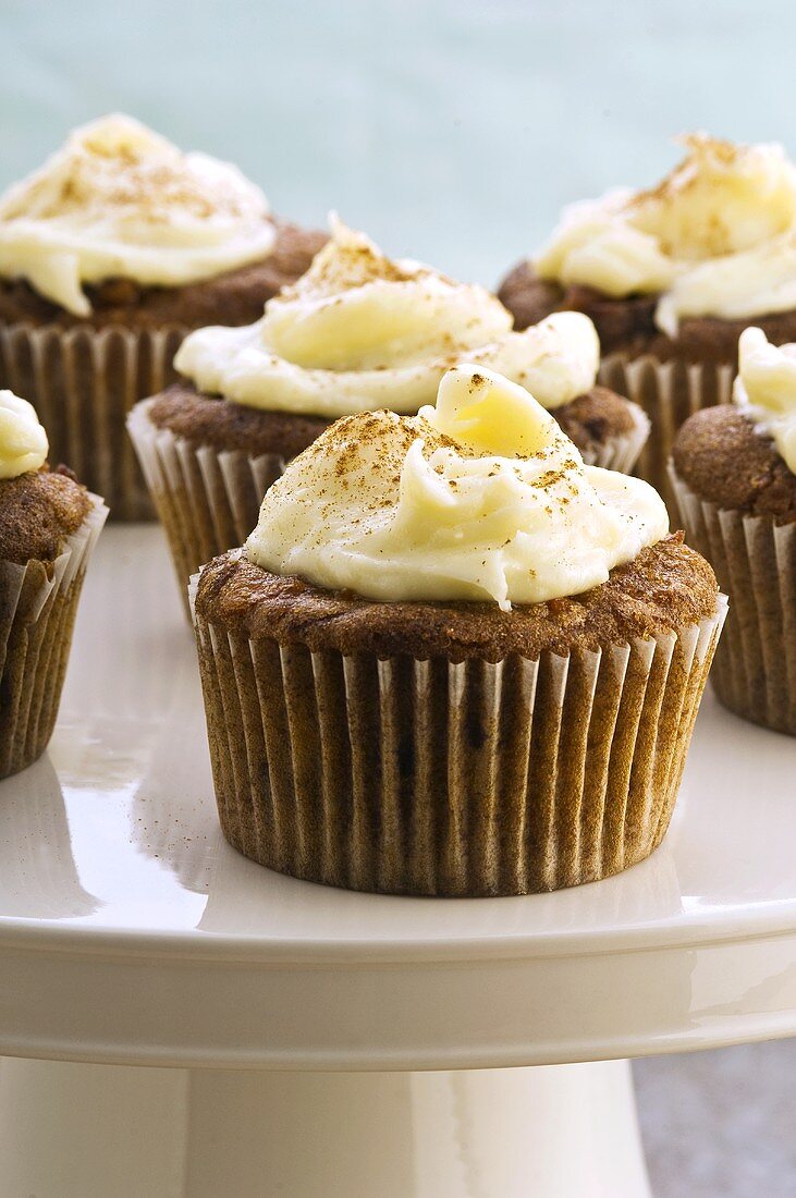 Several carrot cupcakes on cake stand