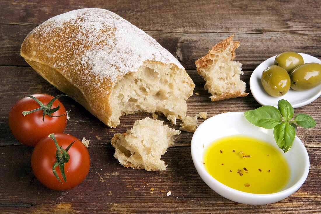 Still life with ciabatta, olive oil, olives and tomatoes