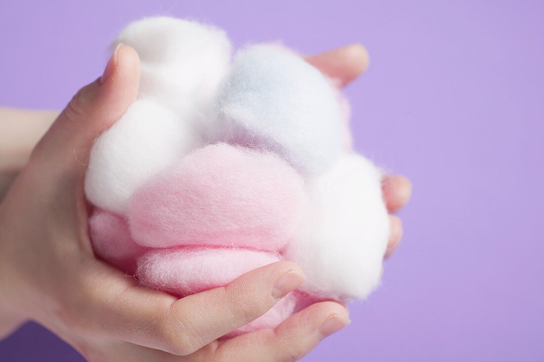 Hands holding cotton wool balls
