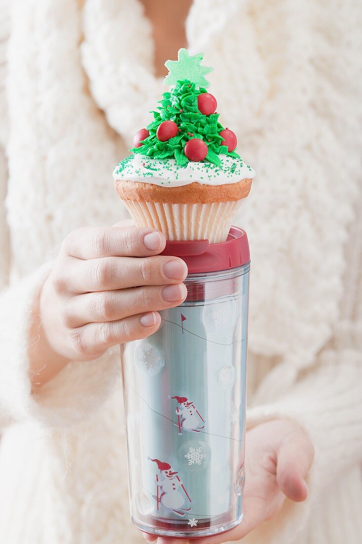 Woman holding cupcake on insulated beaker (Christmas)