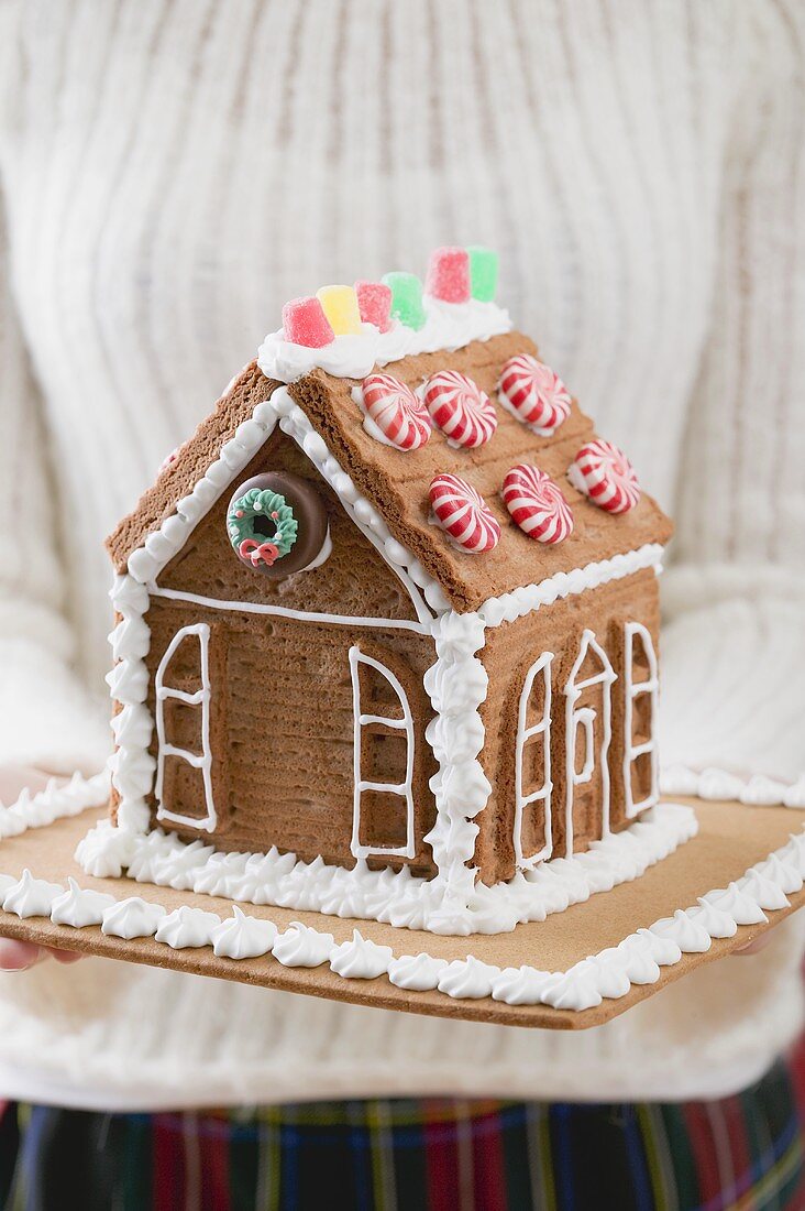 Frau hält Lebkuchenhaus