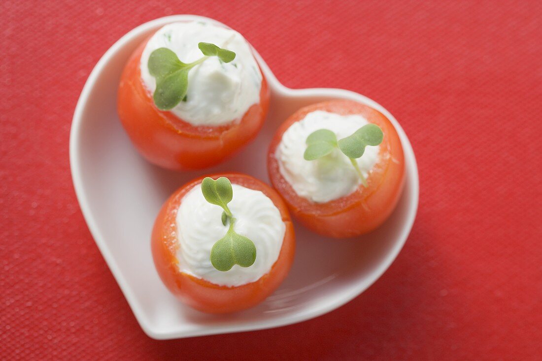 Tomatoes with soft cheese stuffing in heart-shaped dish