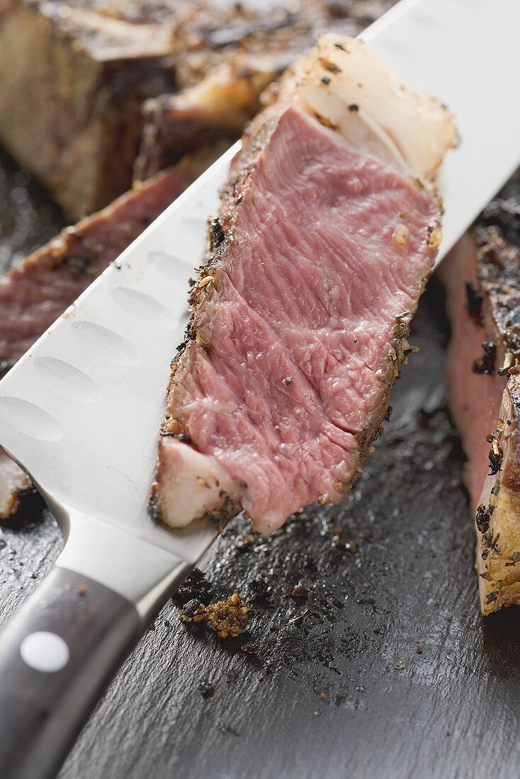 Scheibe von würzigem Ribeye Steak auf Messer (Close Up)