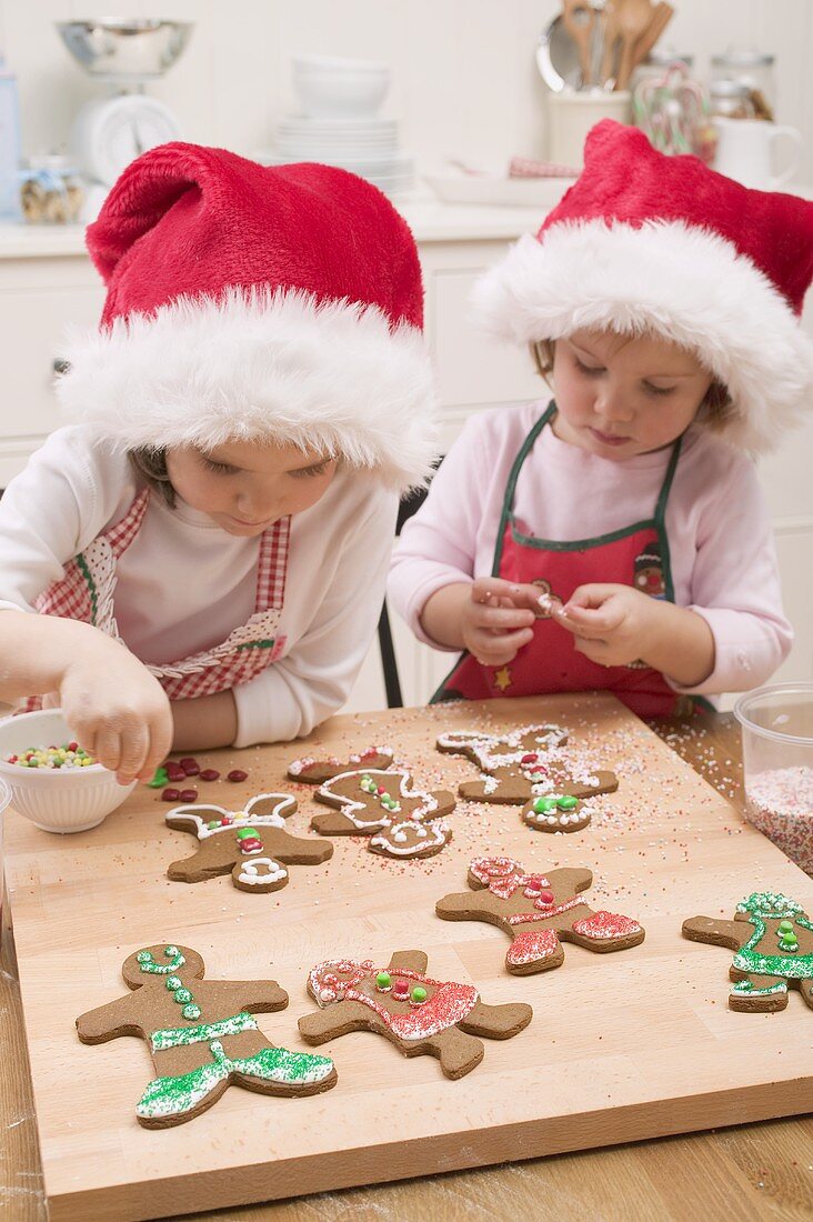 Two small girls decorating gingerbread men