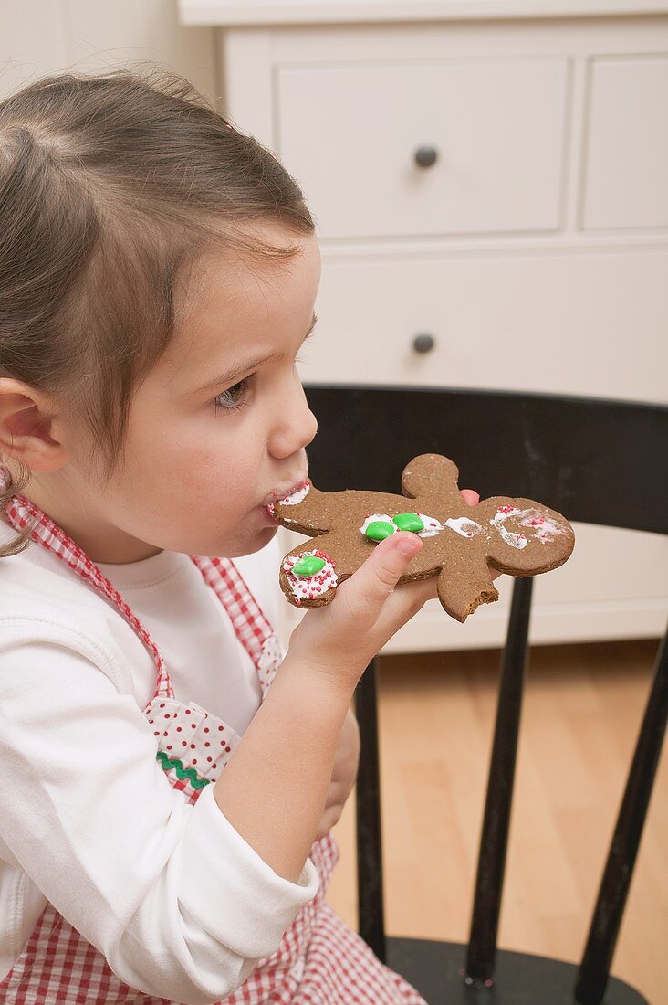 Kleines Mädchen isst Lebkuchenfigur