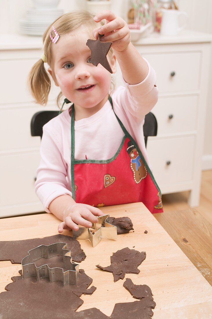 Small girl cutting out chocolate biscuits