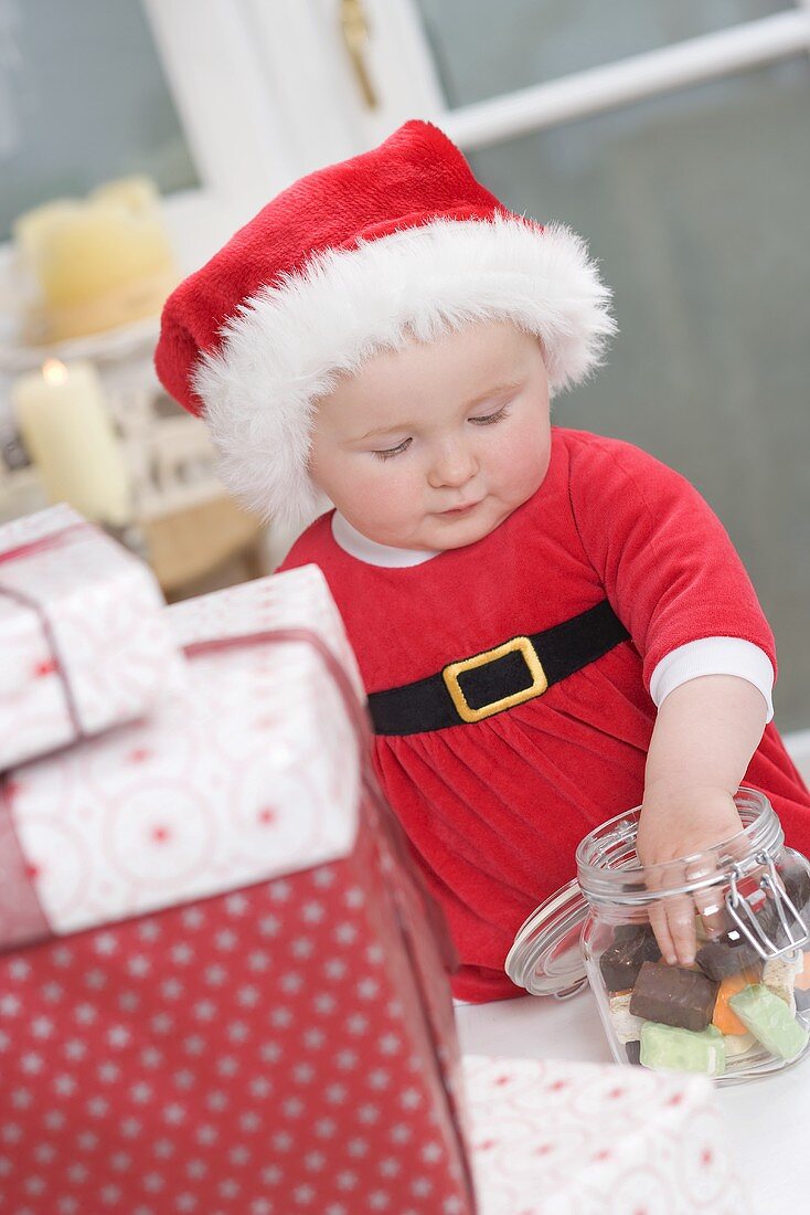 Baby taking sweets out of storage jar