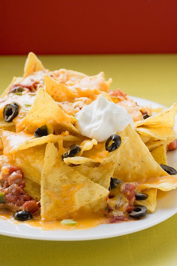 Nachos with melted cheese, olives and sour cream (Mexico)