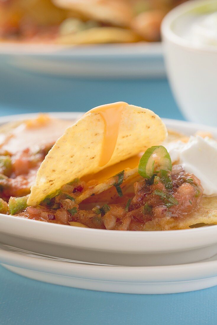 Überbackene Tortillachips mit Käse, Oliven und saurer Sahne