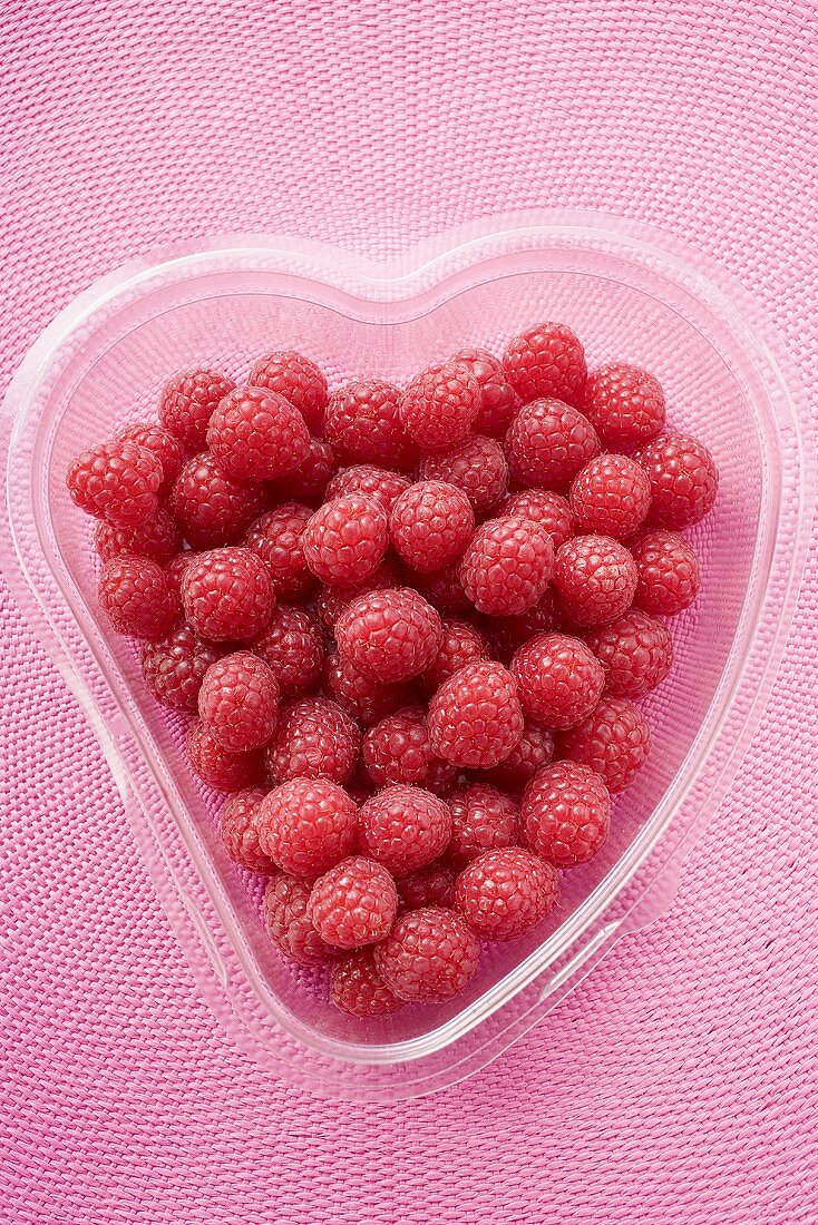 Himbeeren in herzförmiger Plastikschale von oben