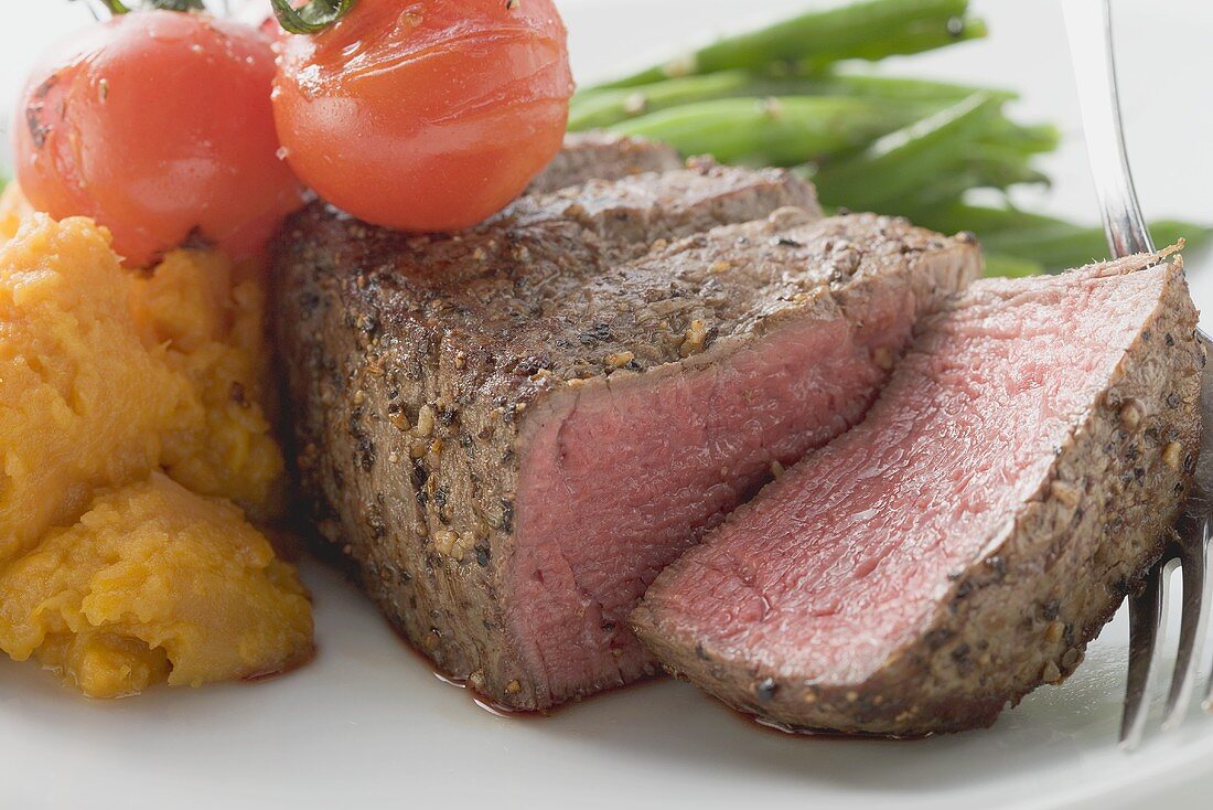 Beef steak, a slice cut off, with vegetables
