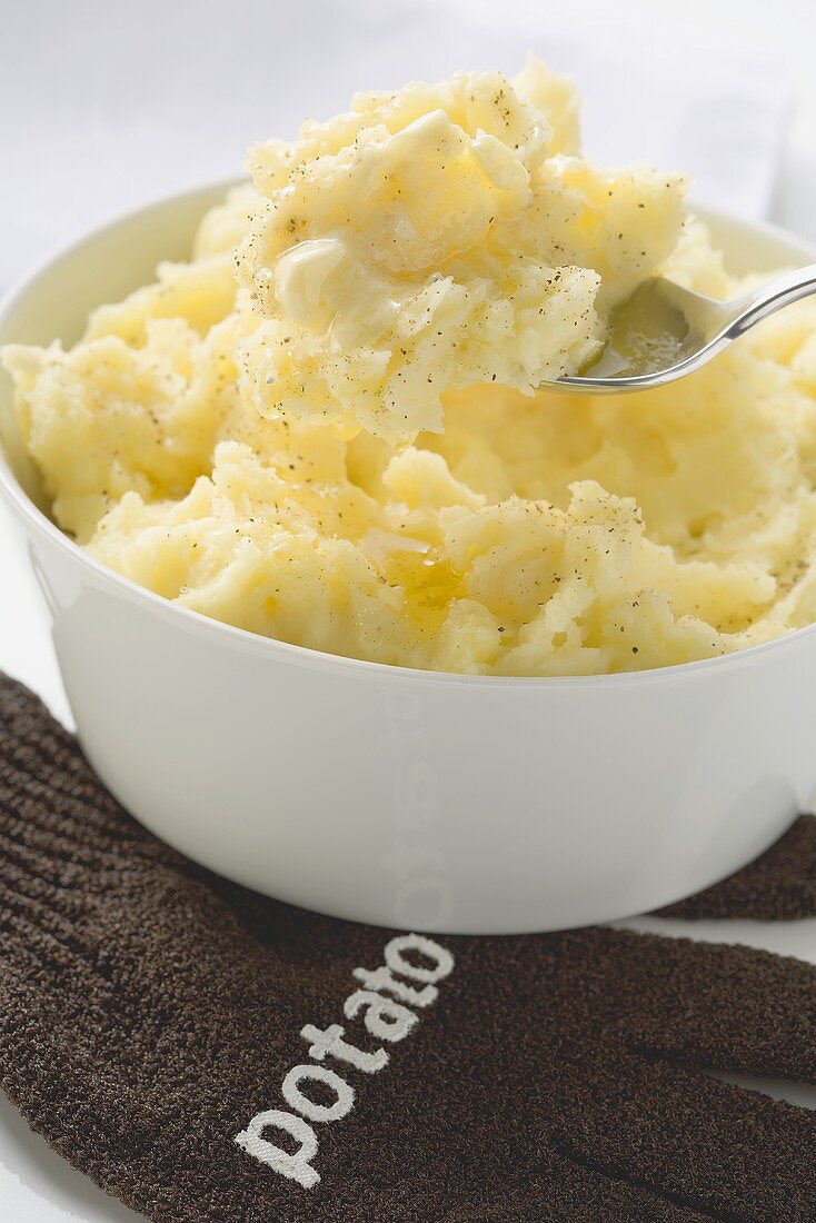 Kartoffelpüree mit Butter in Schale und auf Löffel