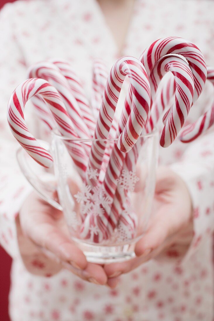 Woman holding glass of candy canes