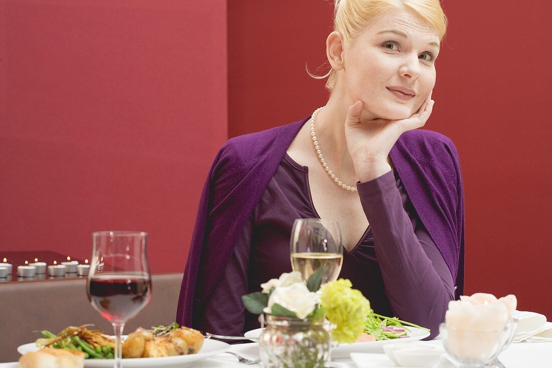 Frau wartet verschmitzt auf den Partner beim Essen