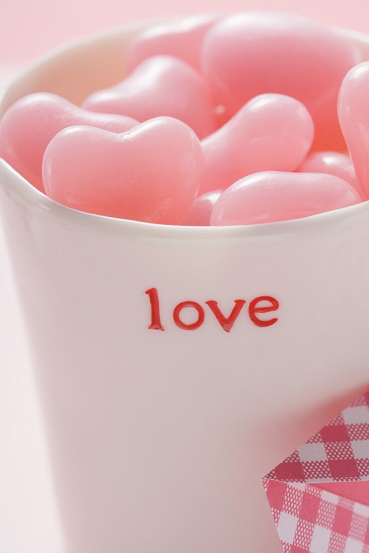 Pink heart-shaped sweets in beaker for Valentine's Day