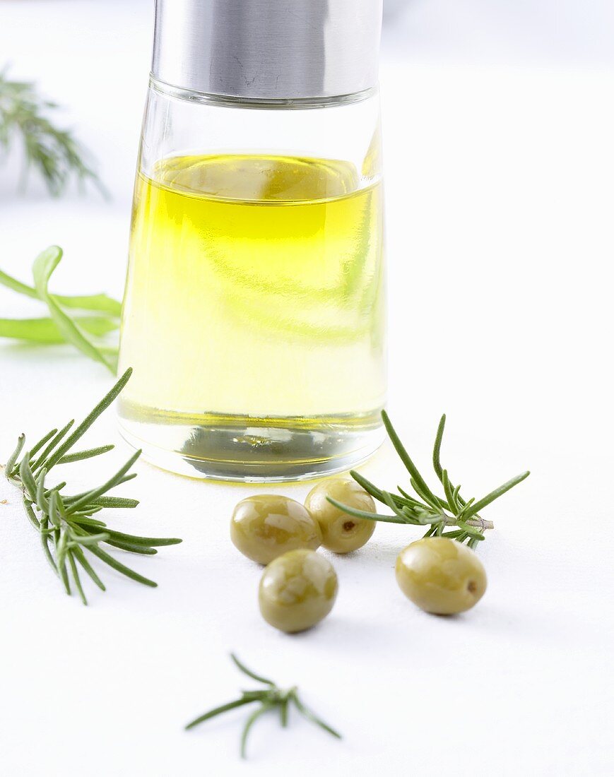 Olivenöl, grüne Oliven und Rosmarin