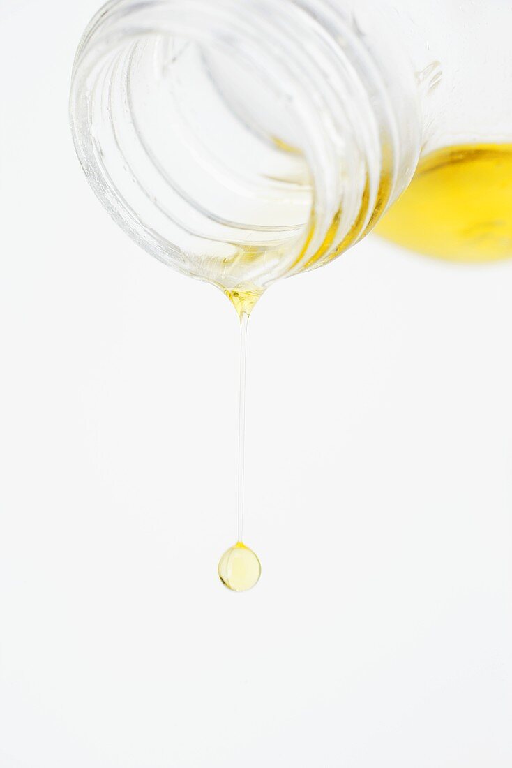 Olive oil dripping out of a bottle