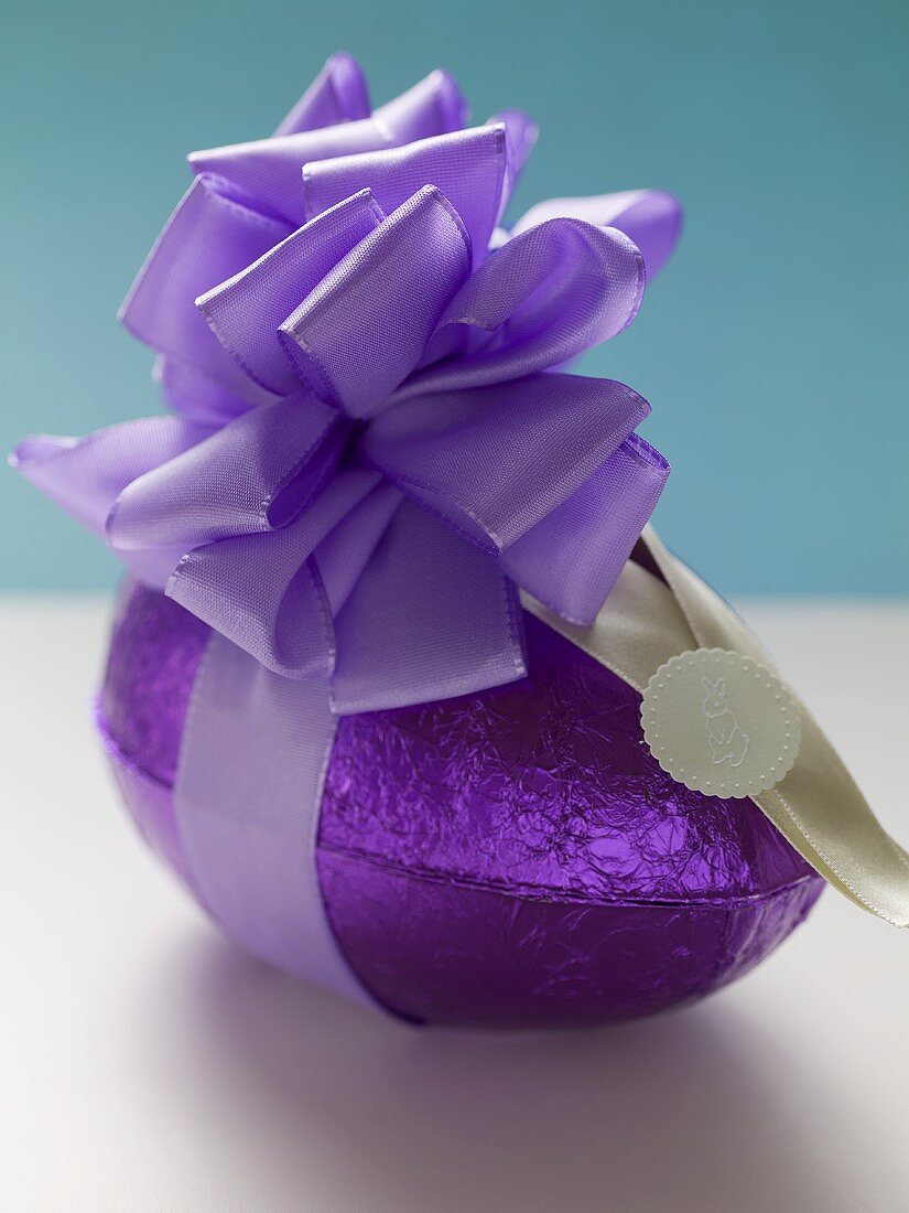 Chocolate Easter egg in purple foil with bow
