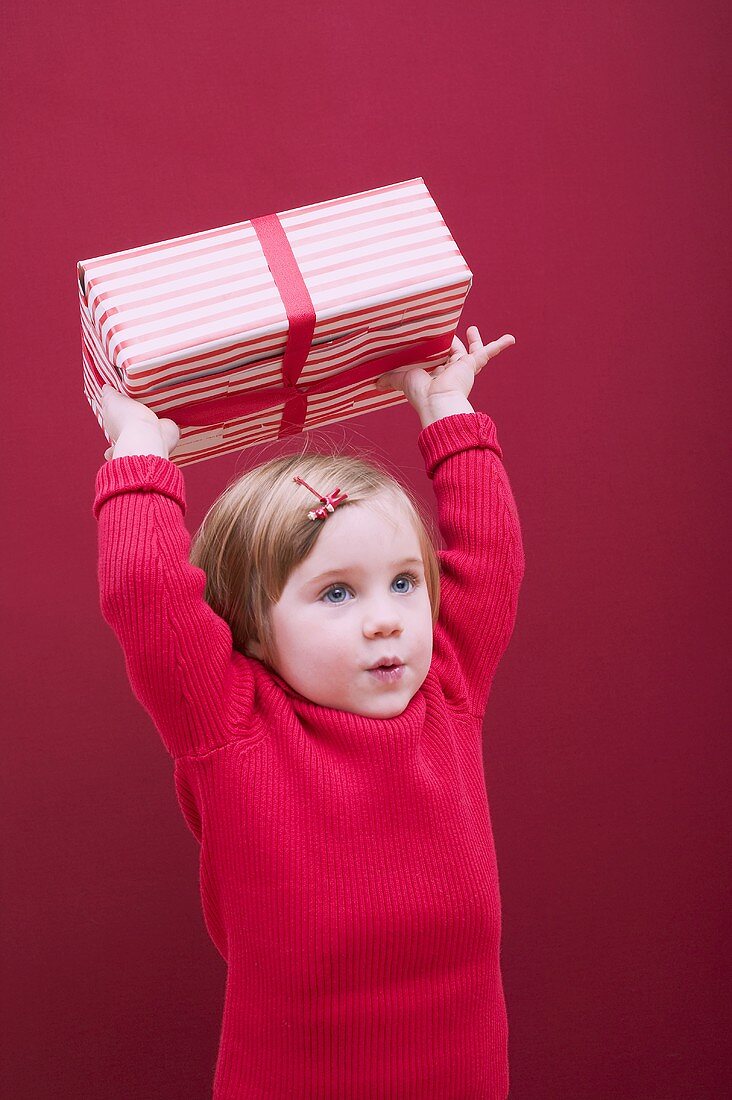 Small girl holding Christmas parcel