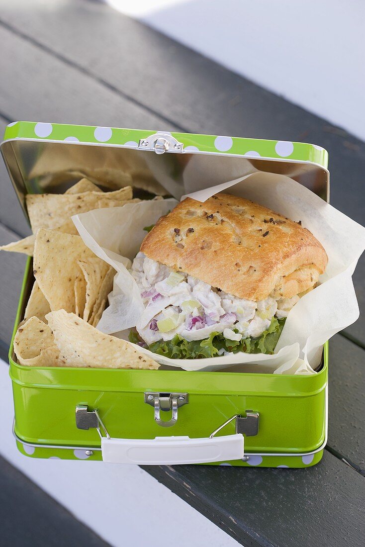 Chicken sandwich and crisps in lunch box