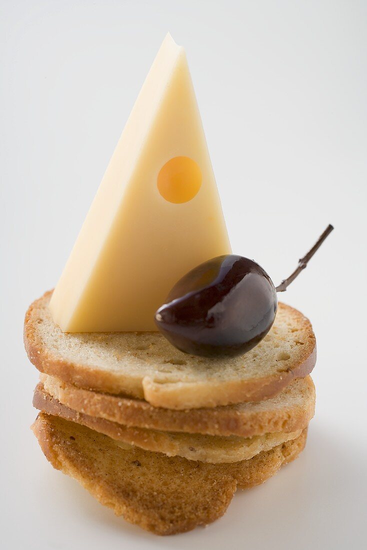 Emmentaler und Olive auf Weissbrotscheiben