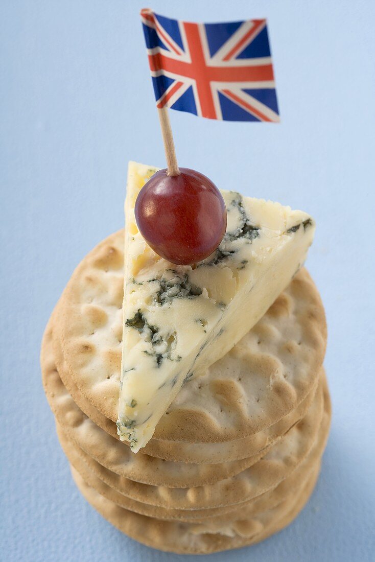 Piece of Stilton with grape and Union Jack on crackers