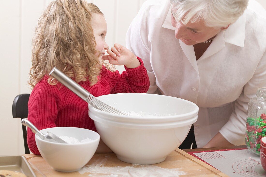 Grandmother and granddaughter baking Christmas biscuits