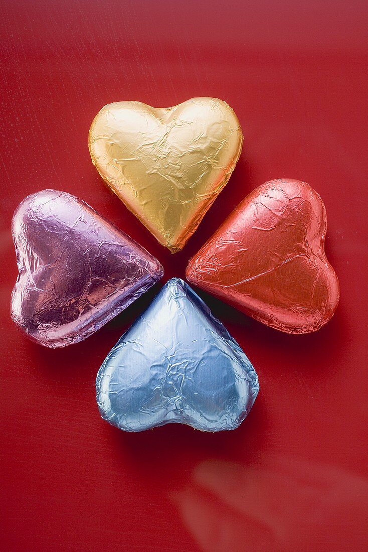 Four heart-shaped chocolates in foil
