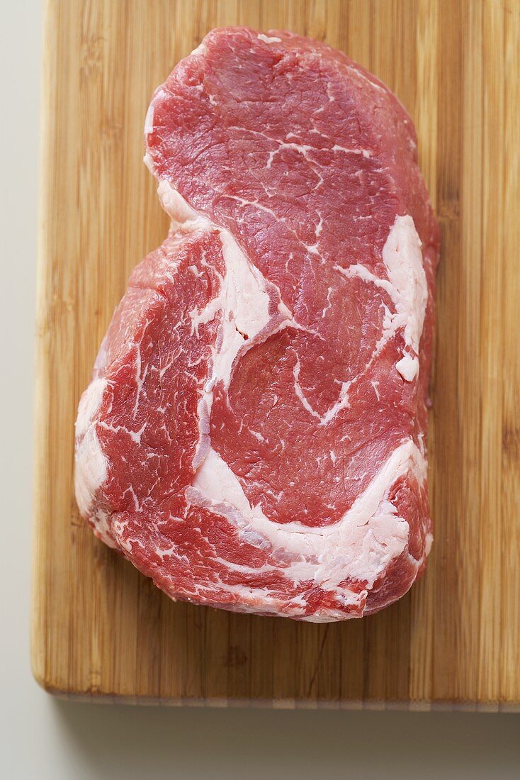Beef steak on chopping board (overhead view)