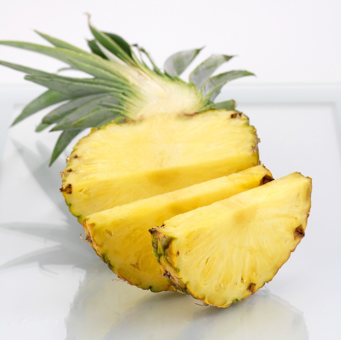 Halbe Ananas, teilweise in Scheiben geschnitten