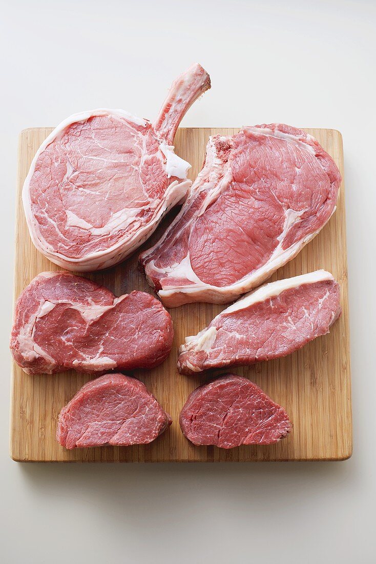 Various cuts of beef on chopping board