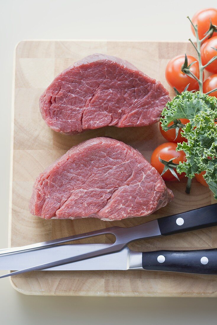 Two pieces of beef fillet on chopping board