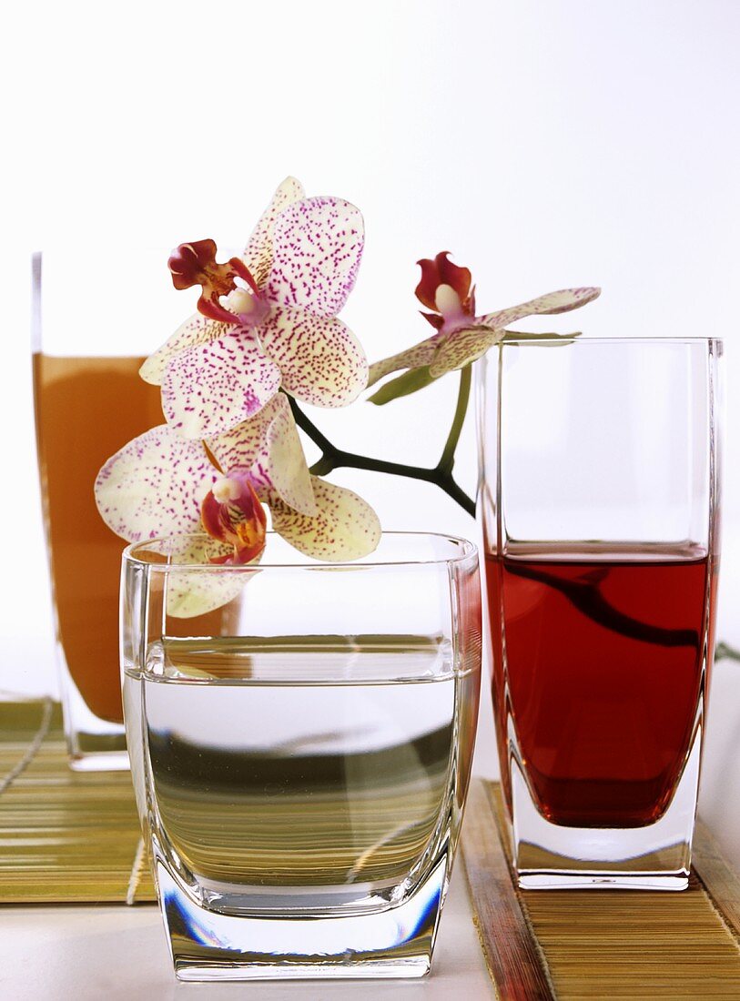 Gläser mit Hibiskussaft und Wasser (mit Orchideenblüten)