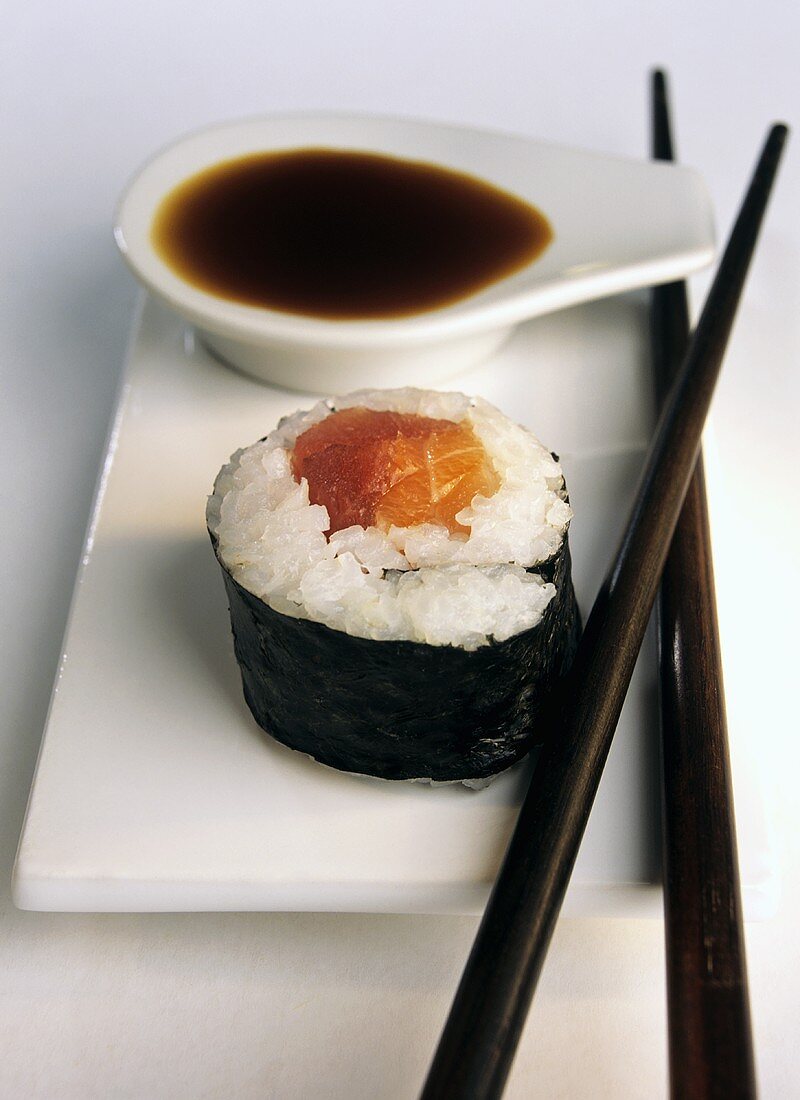 Maki-Sushi mit Lachs, Sojasauce, Essstäbchen