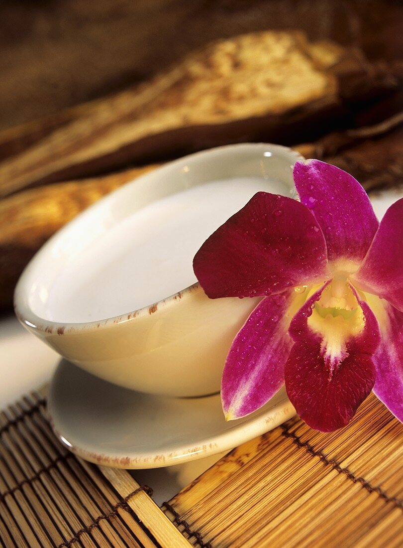 Coconut milk in bowl with orchid